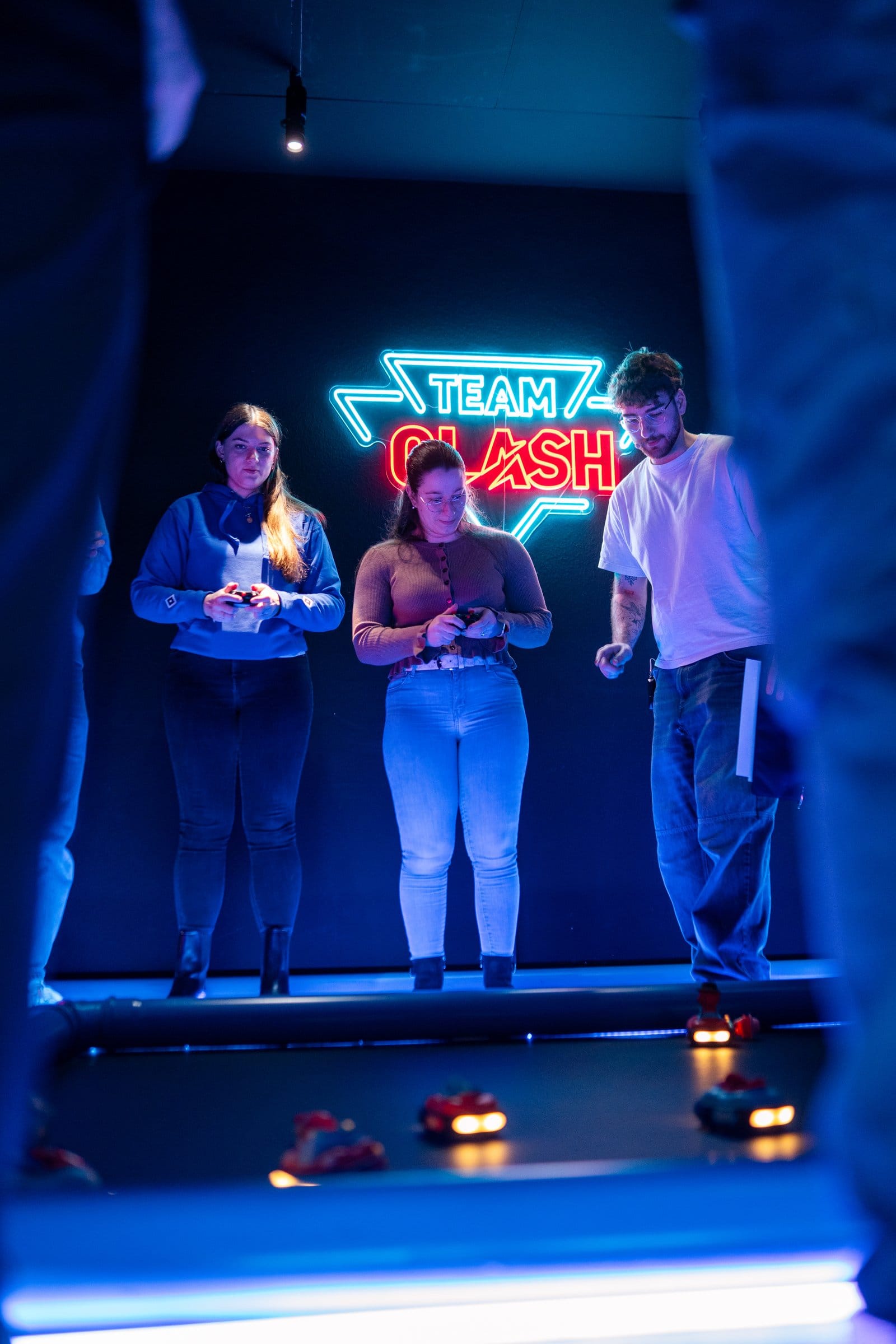 Drei Personen steuern RC-Autos bei Team Clash